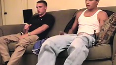 Two sexy studs sit on the couch and feed their passion for masturbation